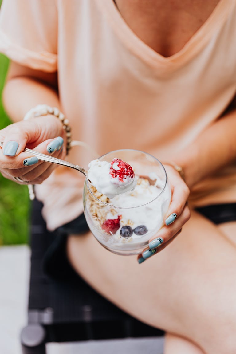 Close-up of Woman Eating Yogurt with Granola and Fruit